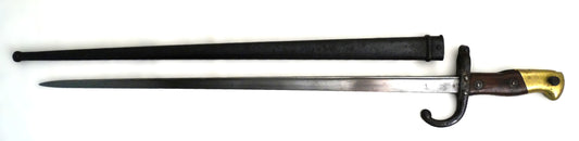Baïonnette Gras modèle 1874 avec poignée laiton et noyer, croisière à quillon et fourreau bronzé. Lame marquée Saint-Étienne, pièce originale de l’époque IIIᵉ République Vue complète coté gauche.