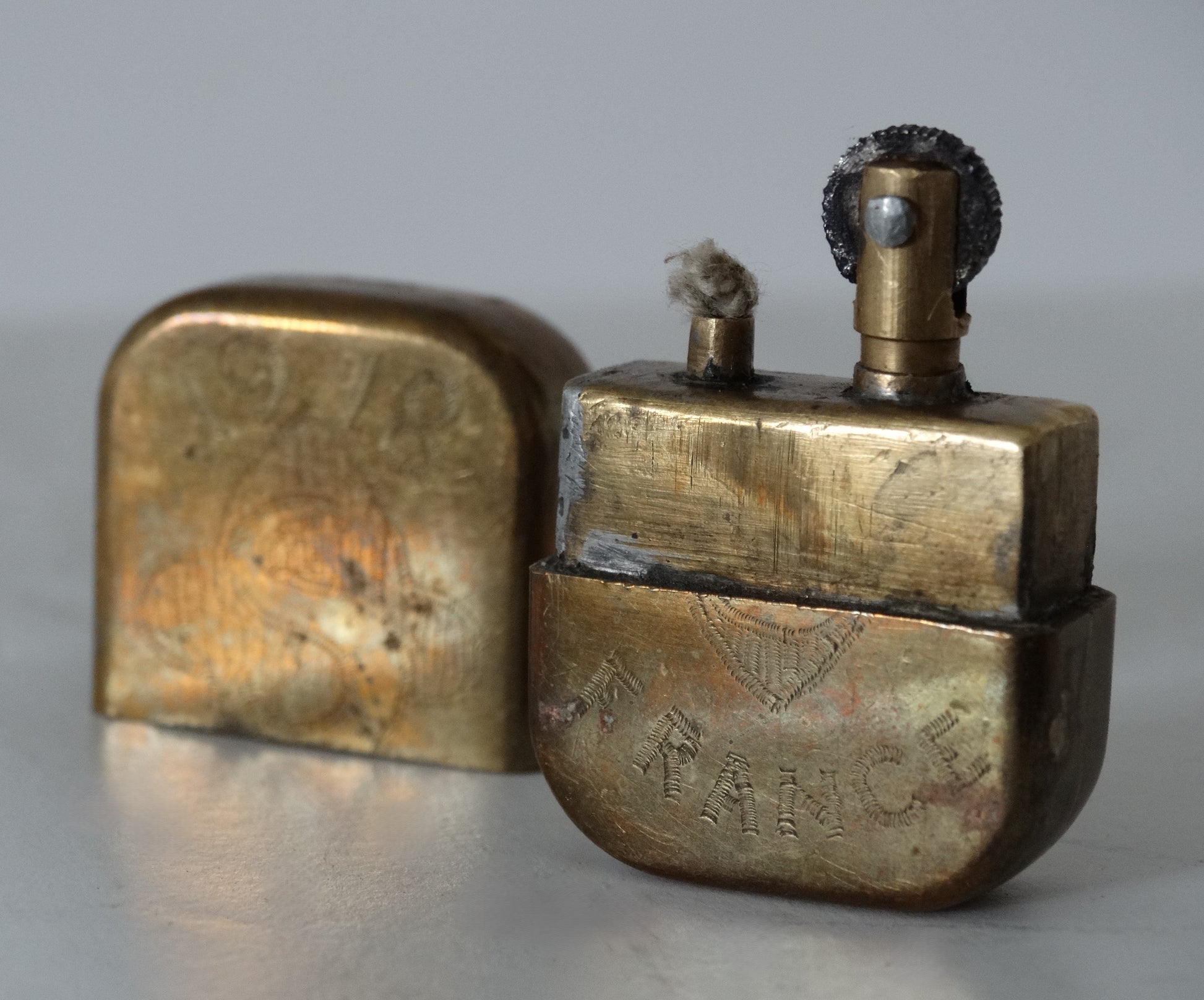 Briquet de tranchée fleurs de lys – Trench Art WW1.
Vue 3/4 face B capuchon à coté.
