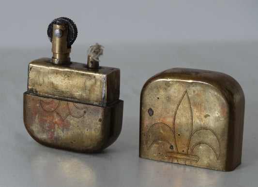 Briquet de tranchée fleurs de lys – Trench Art WW1.
Vue 3/4 face A capuchon à coté.
